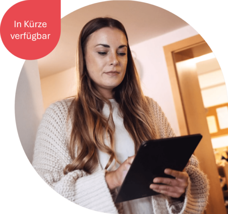 Erzieherin hält ihr Tablet in der Hand. Auf dem Bild steht "In Kürze verfügbar".